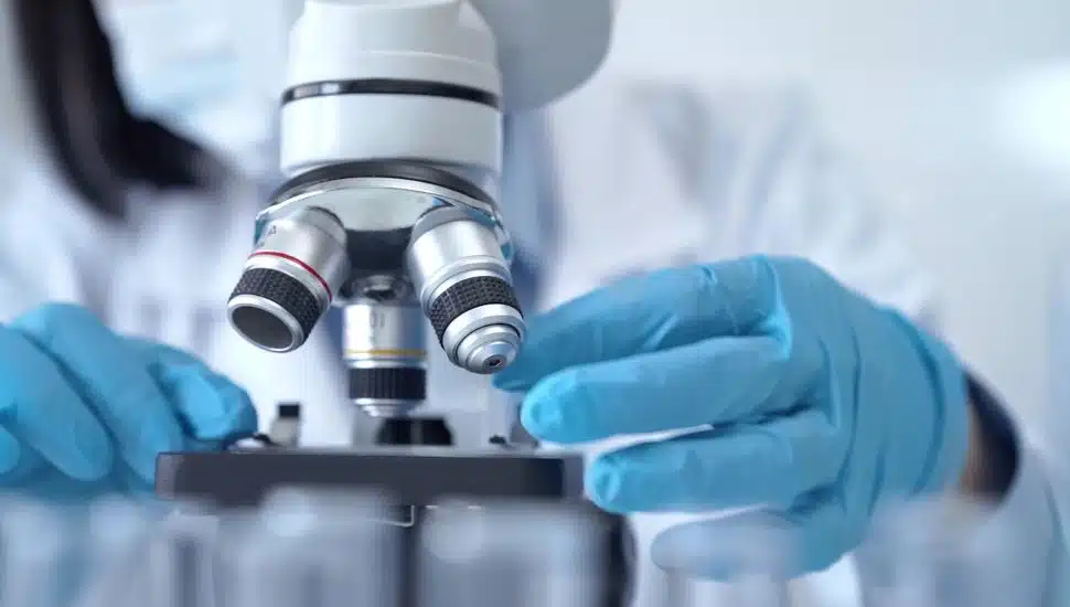 Scientist using microscope in laboratory.