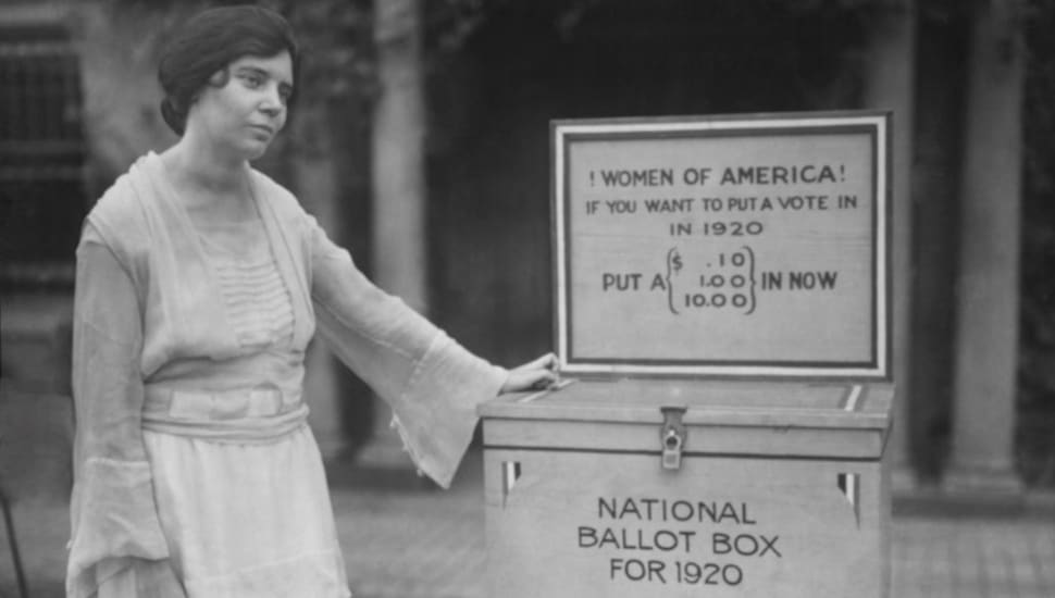 Alice Paul standing by ballot box.
