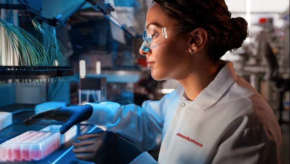 A scientist studies samples under a microscope.