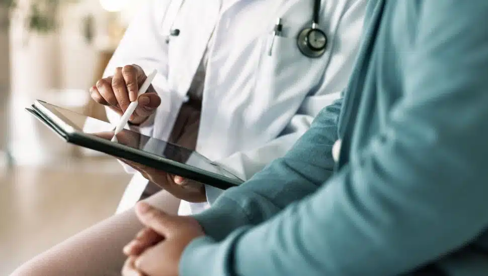 Doctor and patient looking at tablet.