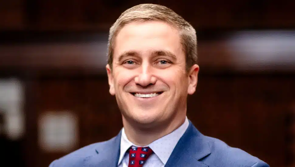 Young male bank executive in blue suit and red tie.