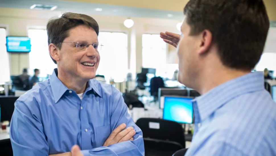 Mike Bontrager, left, talking to another person in an office setting.