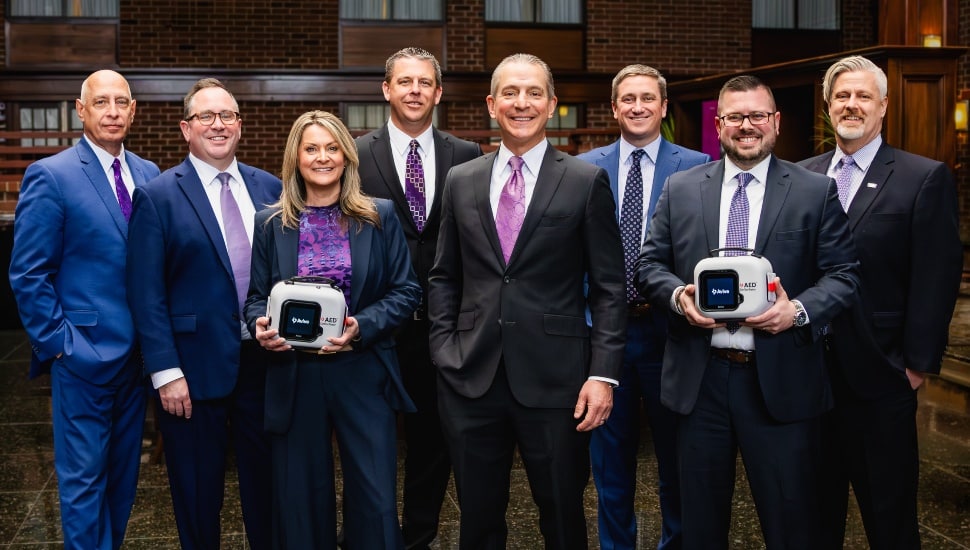 Bank executives wear purple in support of nonprofit.