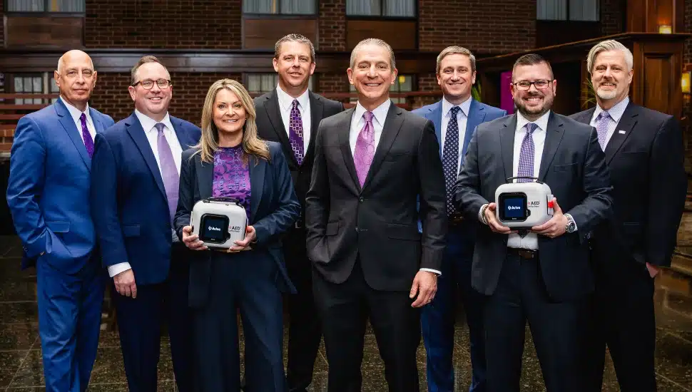 Bank executives wear purple in support of nonprofit.