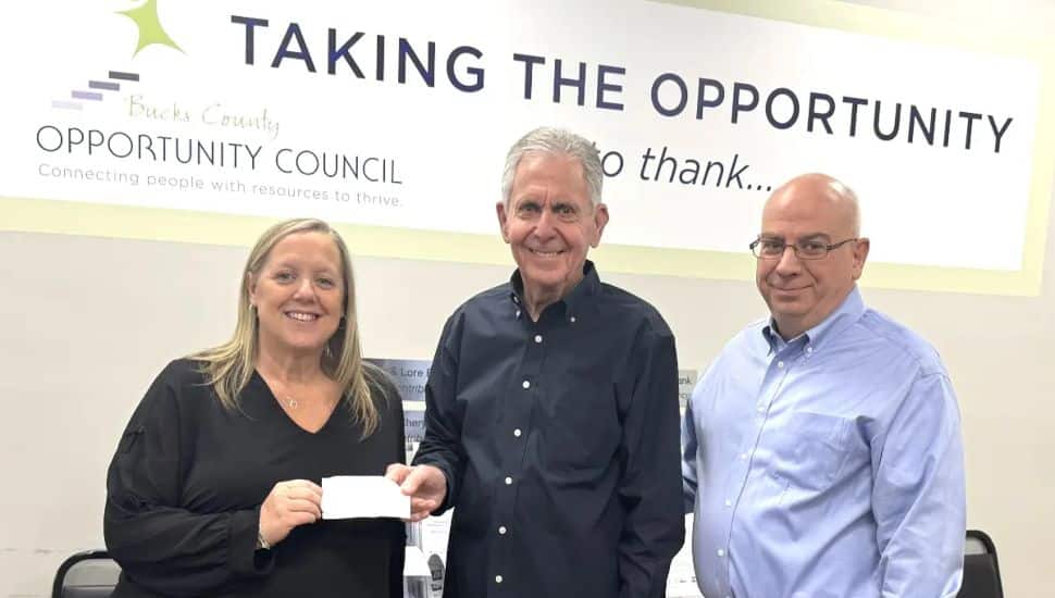 Gene Epstein giving a check to Erin Lukoss and Joe Cuozzo of the BCOC.