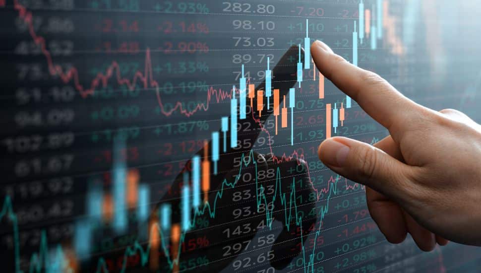 Stocks chart with a person's finger pointing on screen.