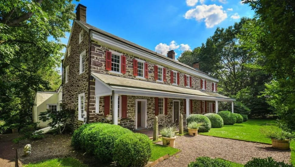 Restores 18th-century farmhouse surrounded by trees and foliage.