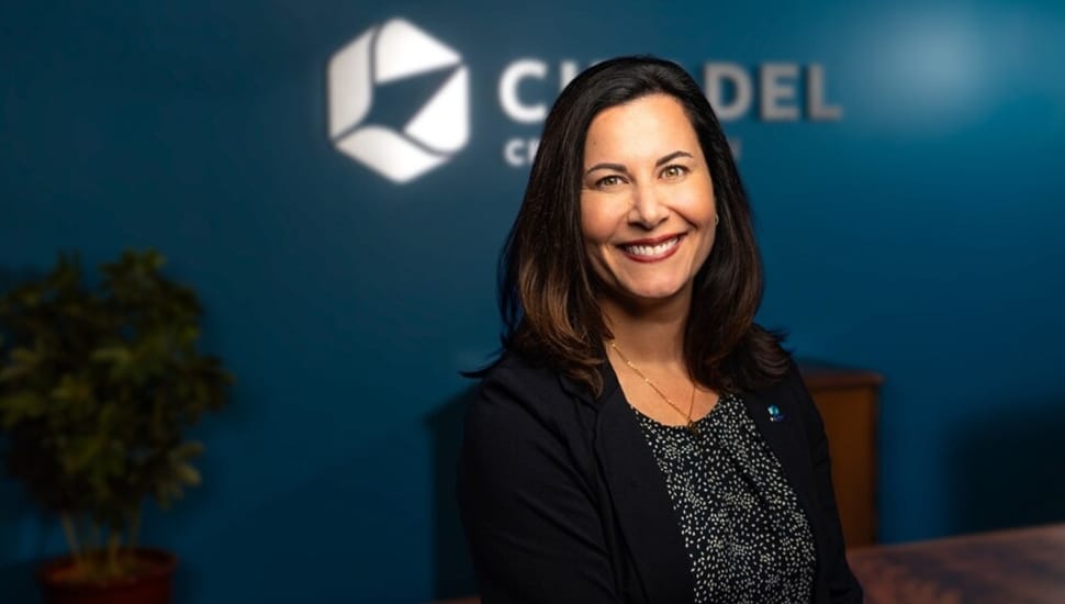 Headshot of female banking executive with dark hair and black jacket.