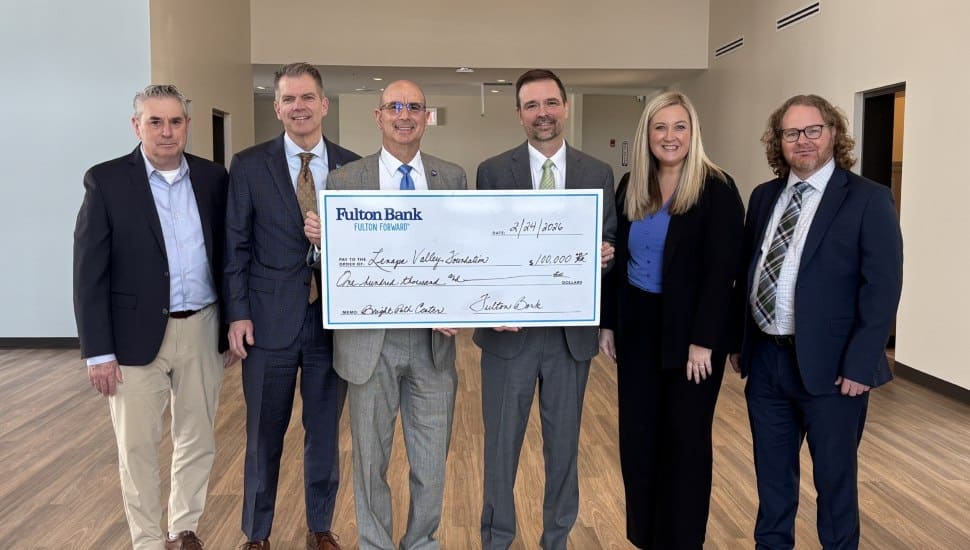 People presenting check.