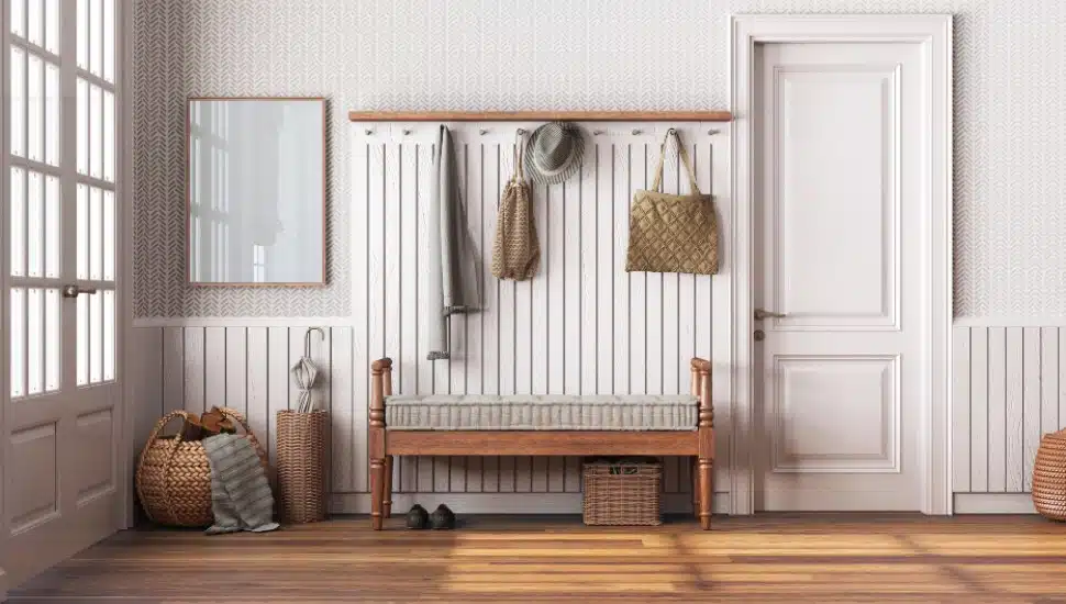 Farmhouse hallway in white and beige tones. Wooden bench and coat rack. Glass, wallpaper and entrance door, scandinavian interior design