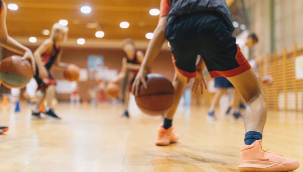 A college basketball player dribbles the ball on the court.