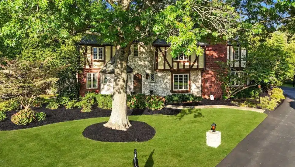 Custom-build storybook-style home surrounded by trees.