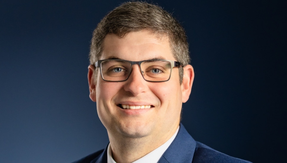 Headshot of middle-aged male banker with glasses.