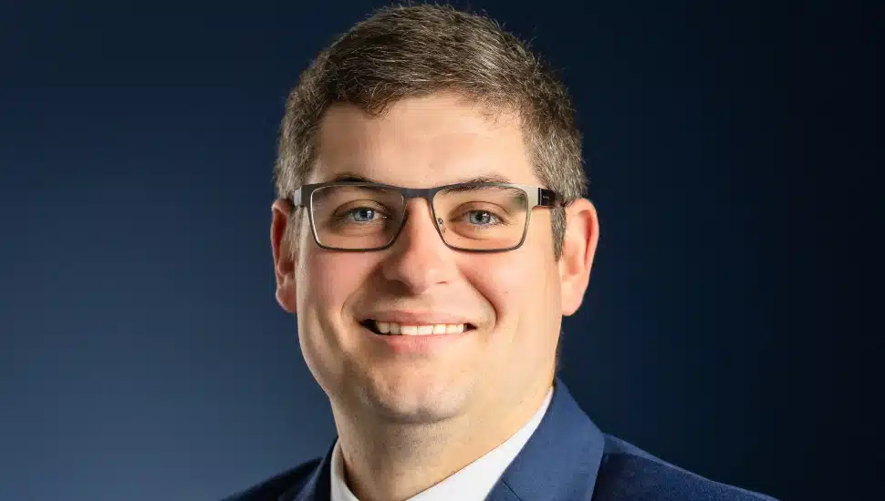 Headshot of middle-aged male banker with glasses.