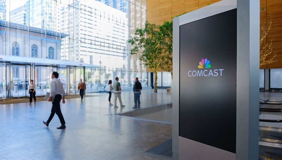 People walking inside Comcast building.