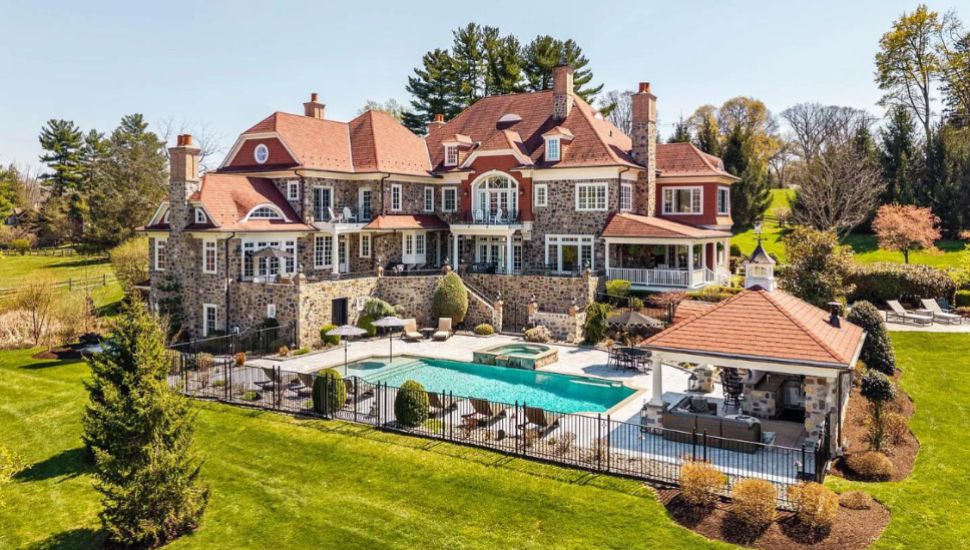Massive Berwyn estate with pool, redish roof, stone exterior.