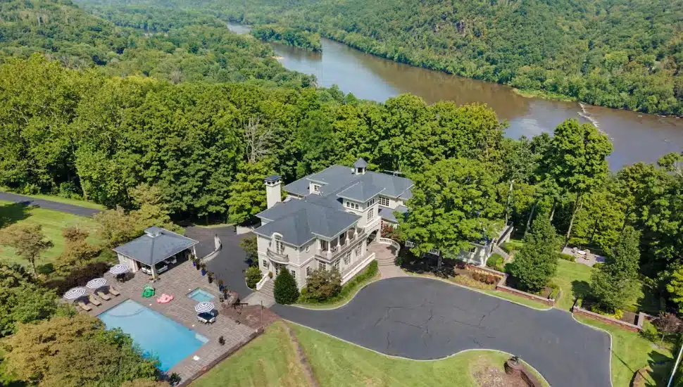 Cliffside Mansion Summer Escape in Tinicum Township sits high above the Delaware River on 12 gated acres, with a resort-sized pool, covered cabana, and sweeping river views that set the tone the moment you arrive.