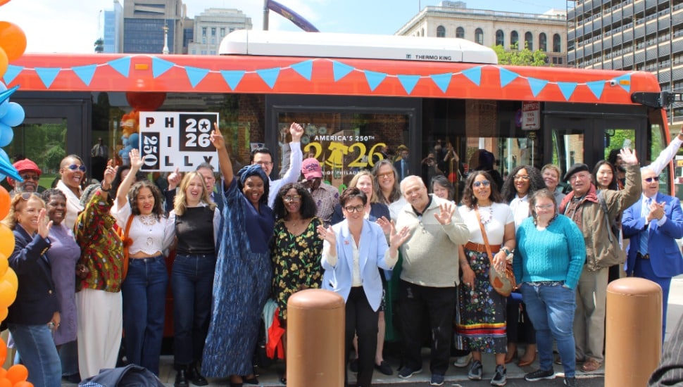Philadelphia representatives, community members, and partners in front of a new tour bus.