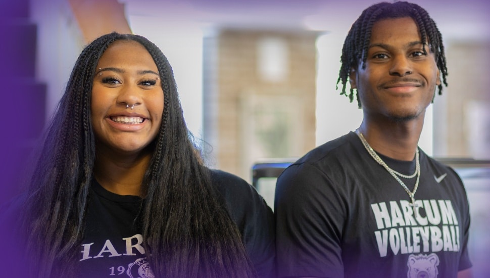 Two smiling Harcum College students wearing Harcum apparel pose together on campus, alongside text reading "Summer Virtual Info Session, Tuesday, June 16."