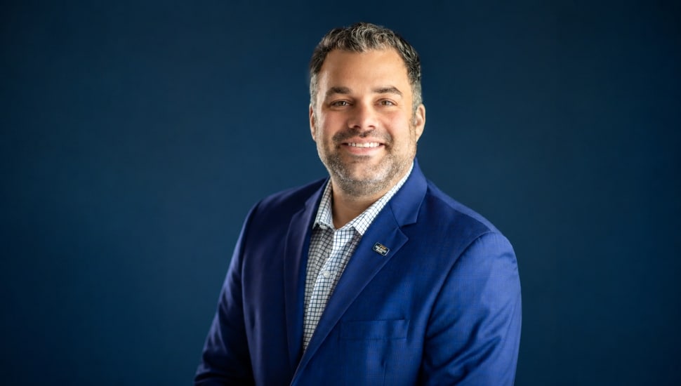 Headshot of male banker in blue suit.