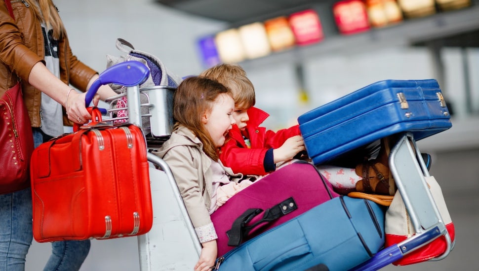 Two little kids, boy and girl, siblings and mother at the airport.